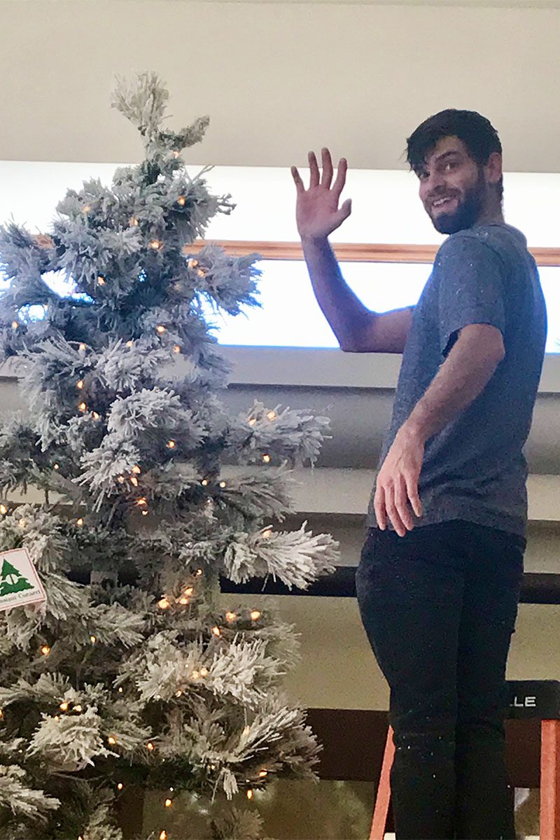 Ben torres Owner, decorating a Christmas Tree